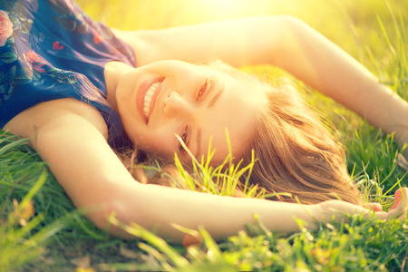 39523225 - beautiful young woman lying on the field in green grass